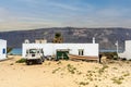 Caleta del Sebo cityscape - sandy roads, 4x4 car, boat and white houses with volcanic Lanzarote island as a background, La Royalty Free Stock Photo