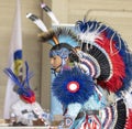 A side view of an indigenous young man talent showcase wearing a colourful traditional cloths.