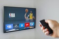 A person using an apple tv remote using the NBA application. Concept watching American