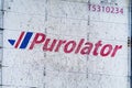 A close up to a Purolator logo to a delivery truck