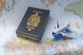 Canadian passport next to an airplane on a world map. Concept: Canadians traveling abroad