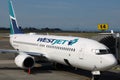 Westjet commercial airplane at loading ramp on a sunny day in Toronto Airport