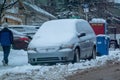 A family van covered in snow following a snowstorm