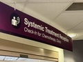 A sign with the text: Systemic Treatment Reception, Check-In for: Chemotherapy, Clinics