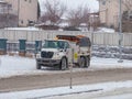 A snow plow and salt spreader working to clear and deice the streets after a winter