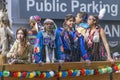 Close up to a young First Nations teens wearing traditional cloths while riding on a