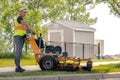 A City of Calgary landscaping worker mowing a public space during the summer