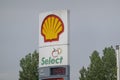 A close up to a Shell logo sign at a gas station and convenient store select