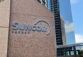 A close up to a Suncor sign with some building on the background