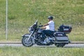 A person driving a motorcycle during a hot day in springtime