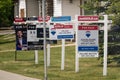 Several real estate property sigs on a side walk