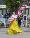 A woman in a hanbok, traditional Korean attire, dancing on a summer day