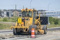 A yellow Caterpillar motor grader