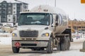 A close-up view of a propane truck navigating wintry roads on a cloudy day
