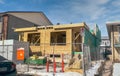 A duplex townhouse under construction, revealing its wooden frame during the winter season