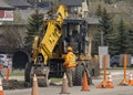 A Construction worker with a backhoe Loader Extendible Dipper Deere during the spring