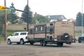 A White truck with a camper RV trailer on the route. Concept: Spring and summer campsite