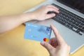 A person using a credit card, Master Card for online shopping with a laptop
