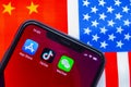 An iPhone with the App Store, TikTok and WeChat applications with a USA and China flag on Royalty Free Stock Photo