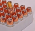 40 caliber hollow point bullets in a plastic case with a single full metal jacket .40 caliber bullet laying on top of them Royalty Free Stock Photo