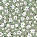 Calico millefleurs seamless pattern. Small white summer wildflowers in a simple hand drawn cartoon style on a green