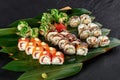 californi sushi set lies on a background of green bamboo leaves on a black background Royalty Free Stock Photo