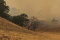 Brush fire causes lots of smoke as it slowly burns down the hill Royalty Free Stock Photo