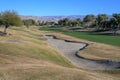 Golf Course sand traps and fairways with mountains in the background.