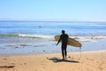 California Pacific Coastal scenery surfer walking into ocean launching