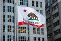 California Republic flag with grizzly bear raised in city downtown