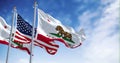 California and USA flags waving in the wind on a clear day