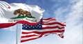 Flags of California and the US waving in the wind on a clear day