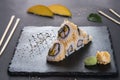 California roll with sesame. Roll with shrimp and mango. Japanese food. Roll on a black shale with Japanese sticks Royalty Free Stock Photo