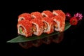 California rolls with salmon and tobiko on bamboo leaf on black background Royalty Free Stock Photo