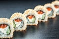 California Sushi maki with salmon and philadelphia cheese on the dark background , focus on one roll