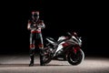 15.10.20, California, USA. A driver in a motorcycle jacket and helmet poses near a sportbike with his arms crossed over his chest