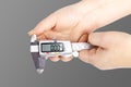 caliper. a device for measuring precision. the size of a part, as well as the diameter. close-up. it is in a person