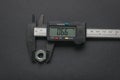 A caliper measuring a nut on a dark background Royalty Free Stock Photo