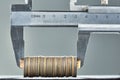 Calipers and stack of coins close-up against gray wall Royalty Free Stock Photo