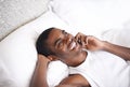 Call, black man and laughing with phone in bed for funny conversation or communication at home. Face of African male Royalty Free Stock Photo