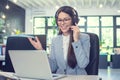 Call center agent woman with headset using laptop and talking to a client via online customer support service Royalty Free Stock Photo