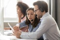 Call center agents in headsets discussing papers helping at workplace Royalty Free Stock Photo