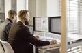 Call center analysts with headsets monitoring data on multiple computer screens Royalty Free Stock Photo