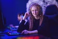 Call center beautiful girl operator professional gamer smiling and talking into a microphone, dark blue neon background Royalty Free Stock Photo