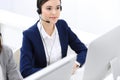 Call center. Beautiful woman receptionist sitting in headset at customer service office. Group of operators at work. Business con