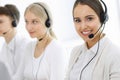 Call center. Group of operators at work. Focus on beautiful woman receptionist in headset at customer service white Royalty Free Stock Photo