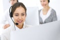 Call center. Group of operators at work. Focus on beautiful woman receptionist in headset at customer service white