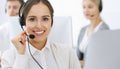 Call center. Group of operators at work. Focus on beautiful woman receptionist in headset at customer service white