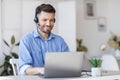 Call center operator at work. Male manager wearing headset and using laptop Royalty Free Stock Photo