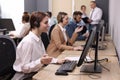 Call center operators working in modern office, focus on young woman with headset Royalty Free Stock Photo